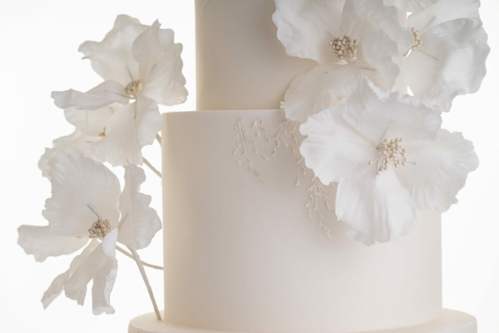 Contemporary hand-crafted sugar flowers on ivory luxury wedding cake by Decorum Taste.