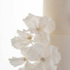 Side detail of hand-crafted sugar flowers on luxury ivory wedding cake, Chic Flowers, by Decorum Taste.