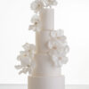 Luxury contemporary 4 tier, customisable wedding cake in ivory with delicate decorative piping and stems of hand-crafted sugar flowers, by Decorum Taste.