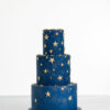 Three tier luxury contemporary, customisable, celebration cake, Cosmos Star by Decorum Taste, in deep blue with flecks of edible gold and golden stars.