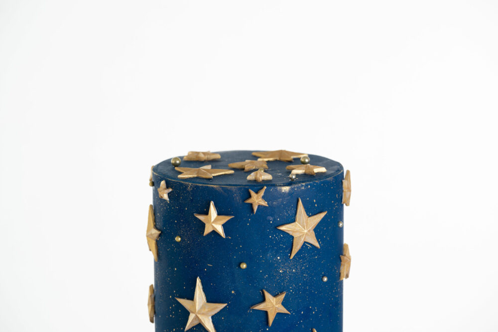 Top tier of luxury contemporary, customisable, celebration cake, Cosmos Star by Decorum Taste, in deep blue with flecks of edible gold and golden stars.