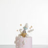 Single tier luxury contemporary, customisable, celebration cake, Cute Elephant by Decorum Taste, in blush pink with hand-crafted elephant in sugar paste sitting on top balancing a balloon, with embellishments of clouds, stars and hearts.