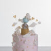 Single tier luxury contemporary, customisable, celebration cake, Cute Elephant by Decorum Taste, in blush pink with hand-crafted elephant in sugar paste sitting on top balancing a balloon, with embellishments of clouds, stars and hearts.