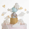 Top of luxury contemporary, customisable, celebration cake, Cute Elephant by Decorum Taste, in blush pink with hand-crafted elephant in sugar paste sitting on top balancing a balloon, with embellishments of clouds, stars and hearts.