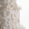 Glittery floral decorative detail and delicate rice paper ruffles on the 4 tier luxury customisable wedding cake, Daphne, by Decorum Taste.