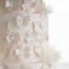 Glittery floral decorative detail and delicate rice paper ruffles on the 4 tier luxury customisable wedding cake, Daphne, by Decorum Taste.