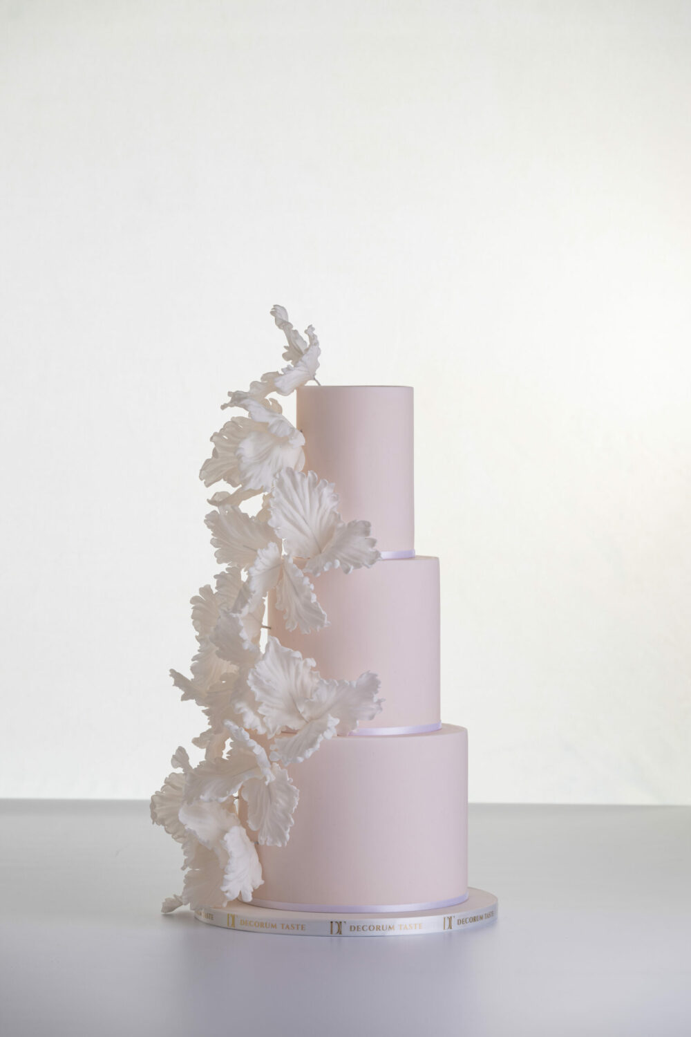 Three tier elegant contemporary customisable wedding cake, Eloise, in soft blush with large hand-crafted sugar flowers, by Decorum Taste.