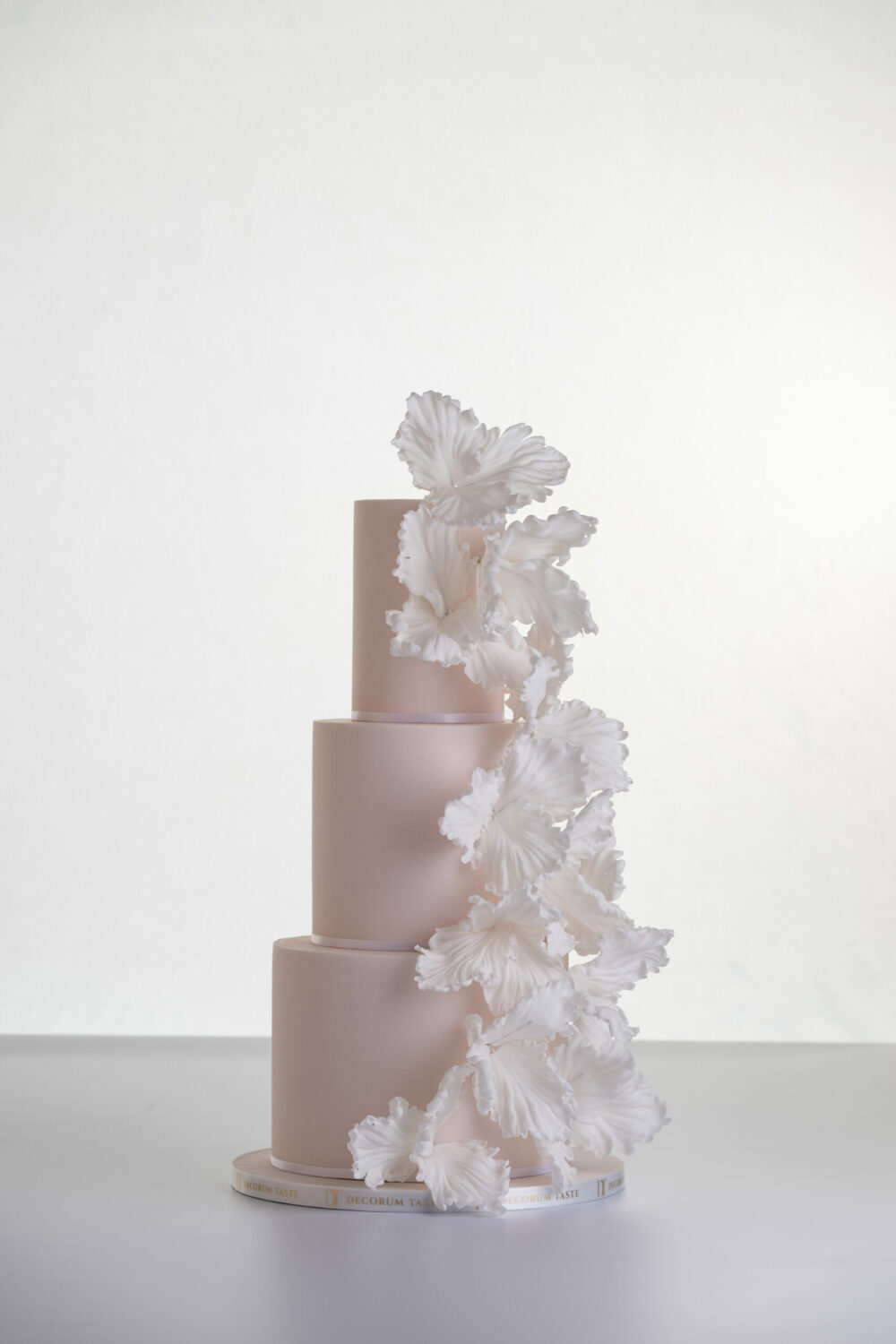 Three tier elegant contemporary customisable wedding cake, Eloise, in soft blush with large hand-crafted sugar flowers, by Decorum Taste.