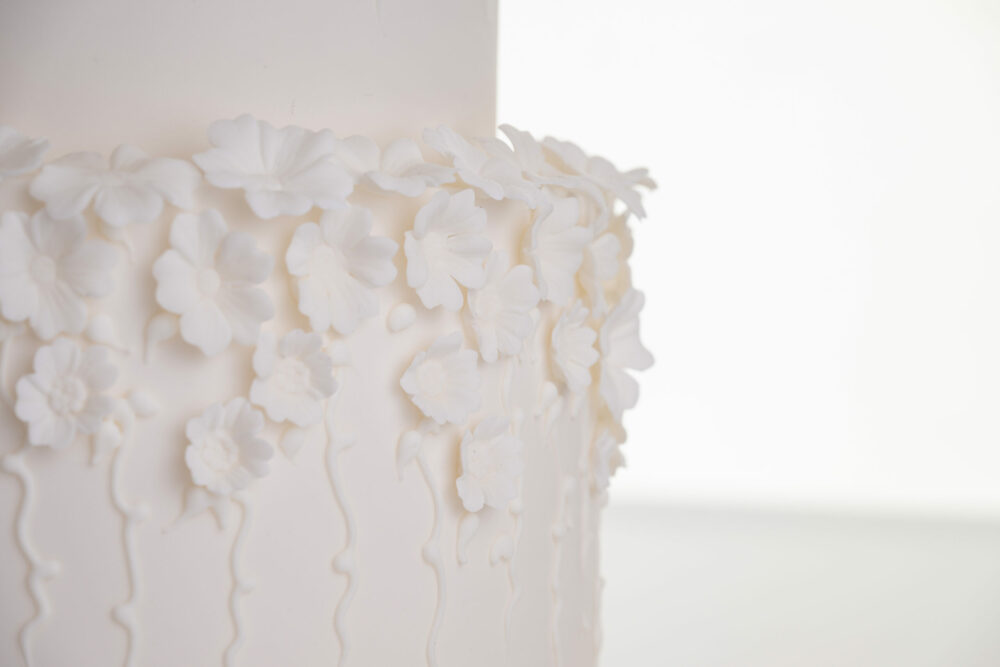 Detail of decorative floral embellishments in ivory on luxury contemporary wedding cake, Fountain of Blossom, by Decorum Taste.