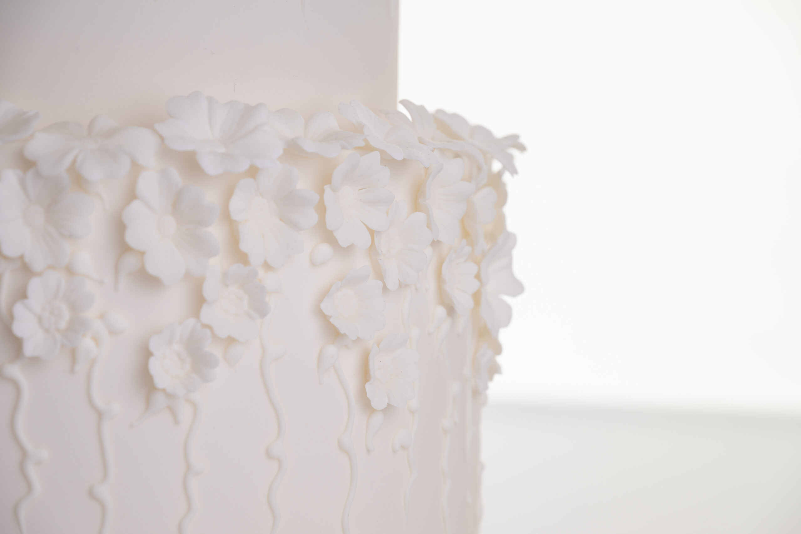 Detail of decorative floral embellishments in ivory on luxury contemporary wedding cake, Fountain of Blossom, by Decorum Taste.