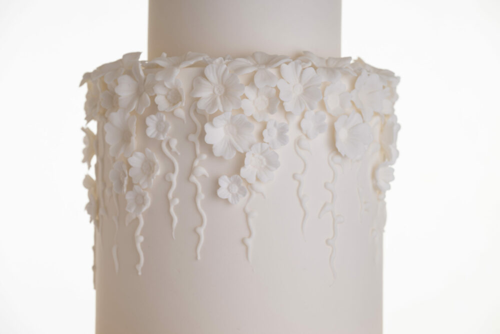 Detail of decorative floral embellishments in ivory on luxury contemporary wedding cake, Fountain of Blossom, by Decorum Taste.