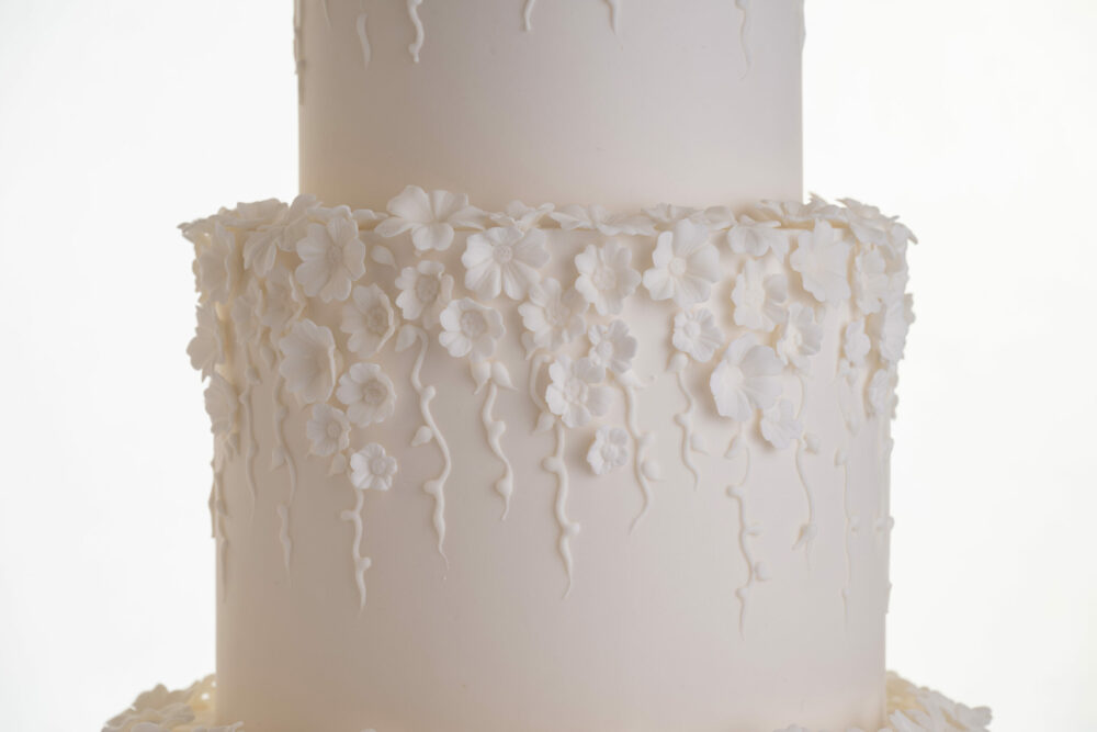 Detail of decorative floral embellishments in ivory on luxury contemporary wedding cake, Fountain of Blossom, by Decorum Taste.