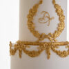 Gold monogram on luxury wedding cake, Lilibet, with gold decorative swags and bows, by Decorum Taste.