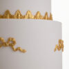 Detail of luxury customisable wedding cake with gold decorative bows by Decorum Taste.