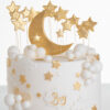 Top of luxury contemporary, customisable, celebration cake, Moon Baby by Decorum Taste, in ivory with large golden moon, stars and clouds.