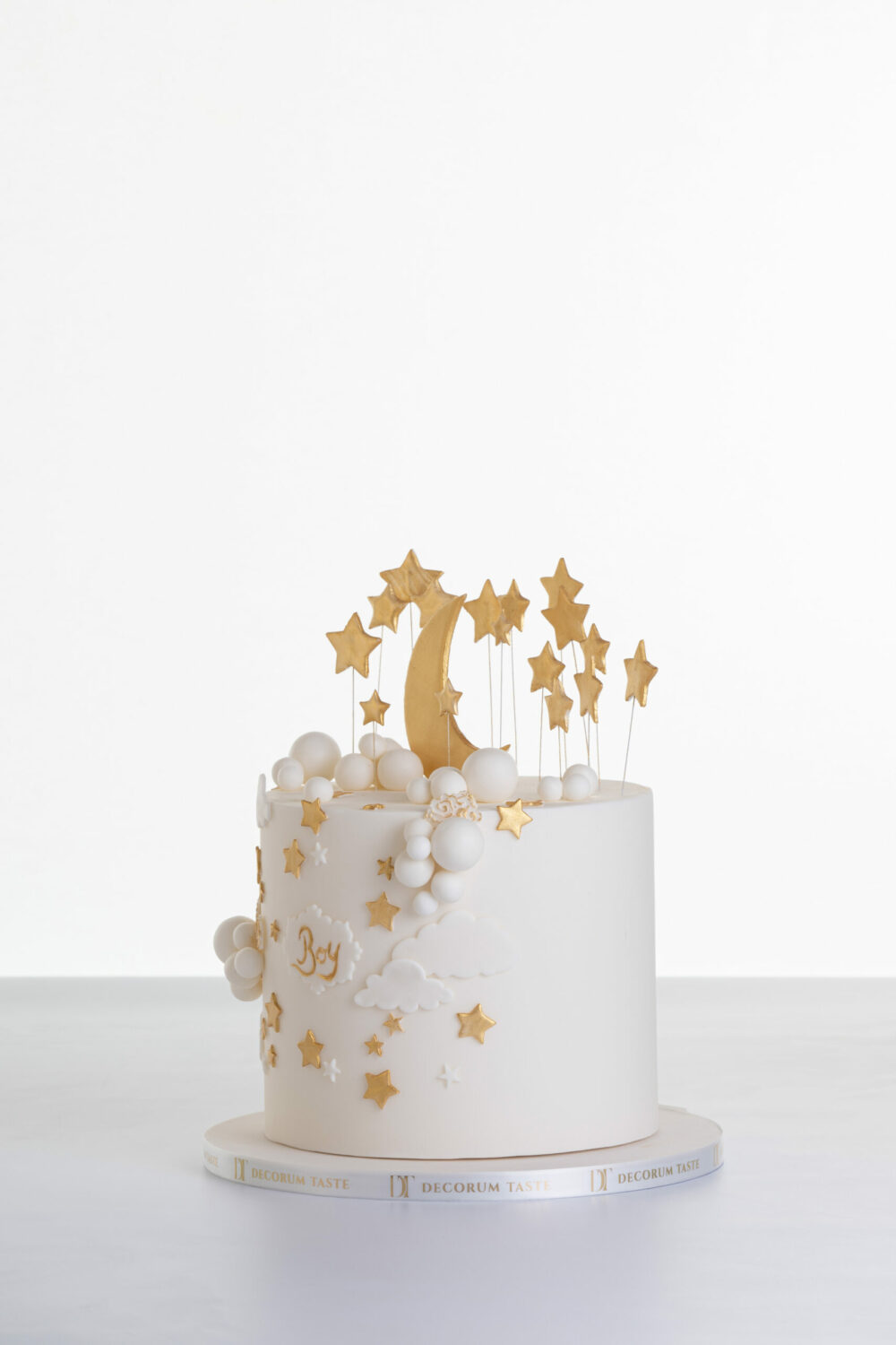 Single tier luxury contemporary, customisable, celebration cake, Moon Baby by Decorum Taste, in ivory with large golden moon, stars and clouds.