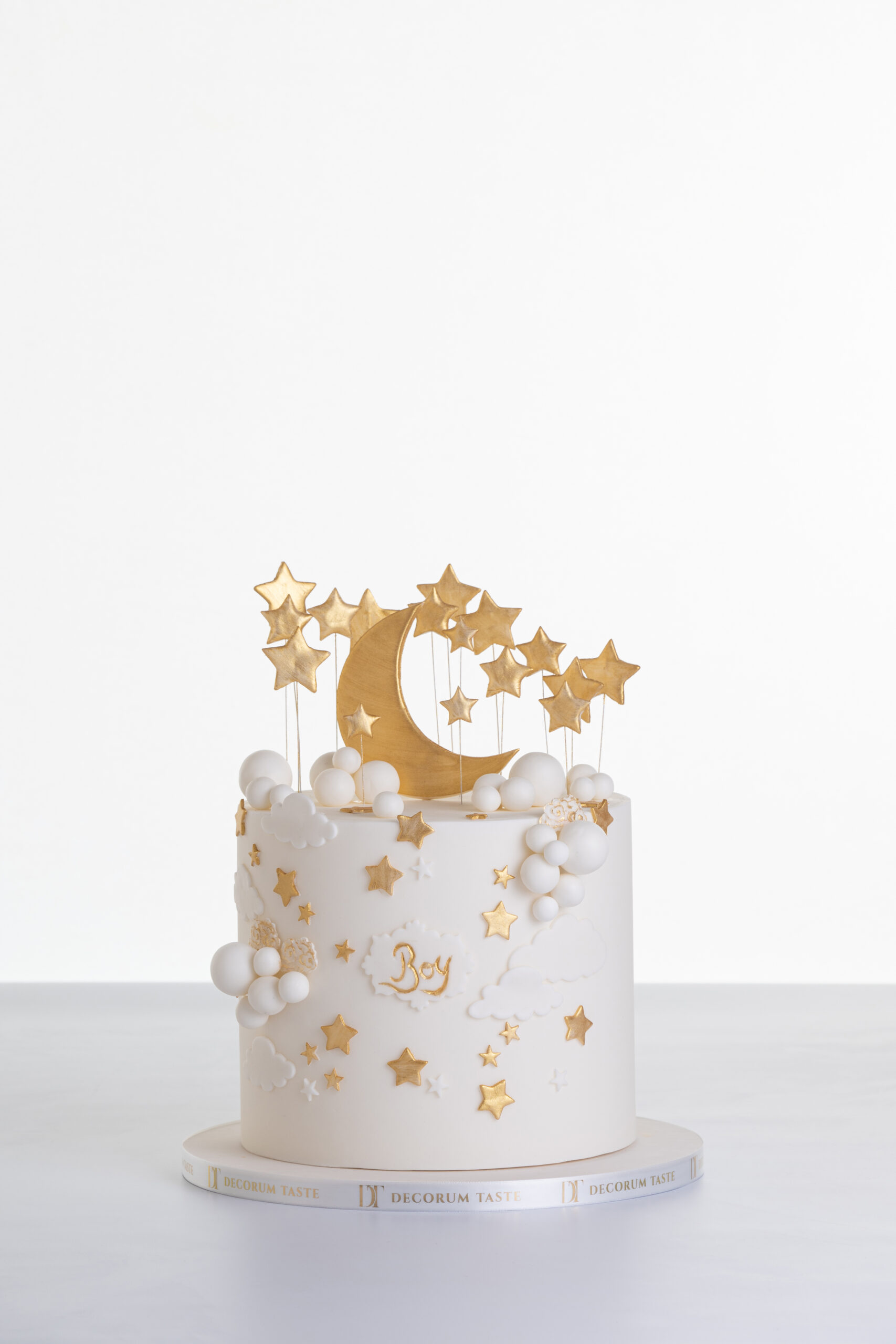 Single tier luxury contemporary, customisable, celebration cake, Moon Baby by Decorum Taste, in ivory with large golden moon, stars and clouds.