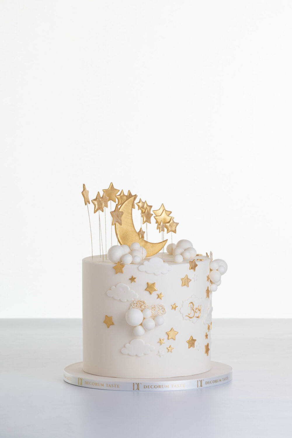 Single tier luxury contemporary, customisable, celebration cake, Moon Baby by Decorum Taste, in ivory with large golden moon, stars and clouds.