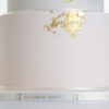 Bottom tier of luxury contemporary, customisable, wedding cake, Orchid Heaven by Decorum Taste, in blush pink and brushes of edible gold leaf. The side of the cake board is decorated in a Decorum Tase logo branded ribbon.