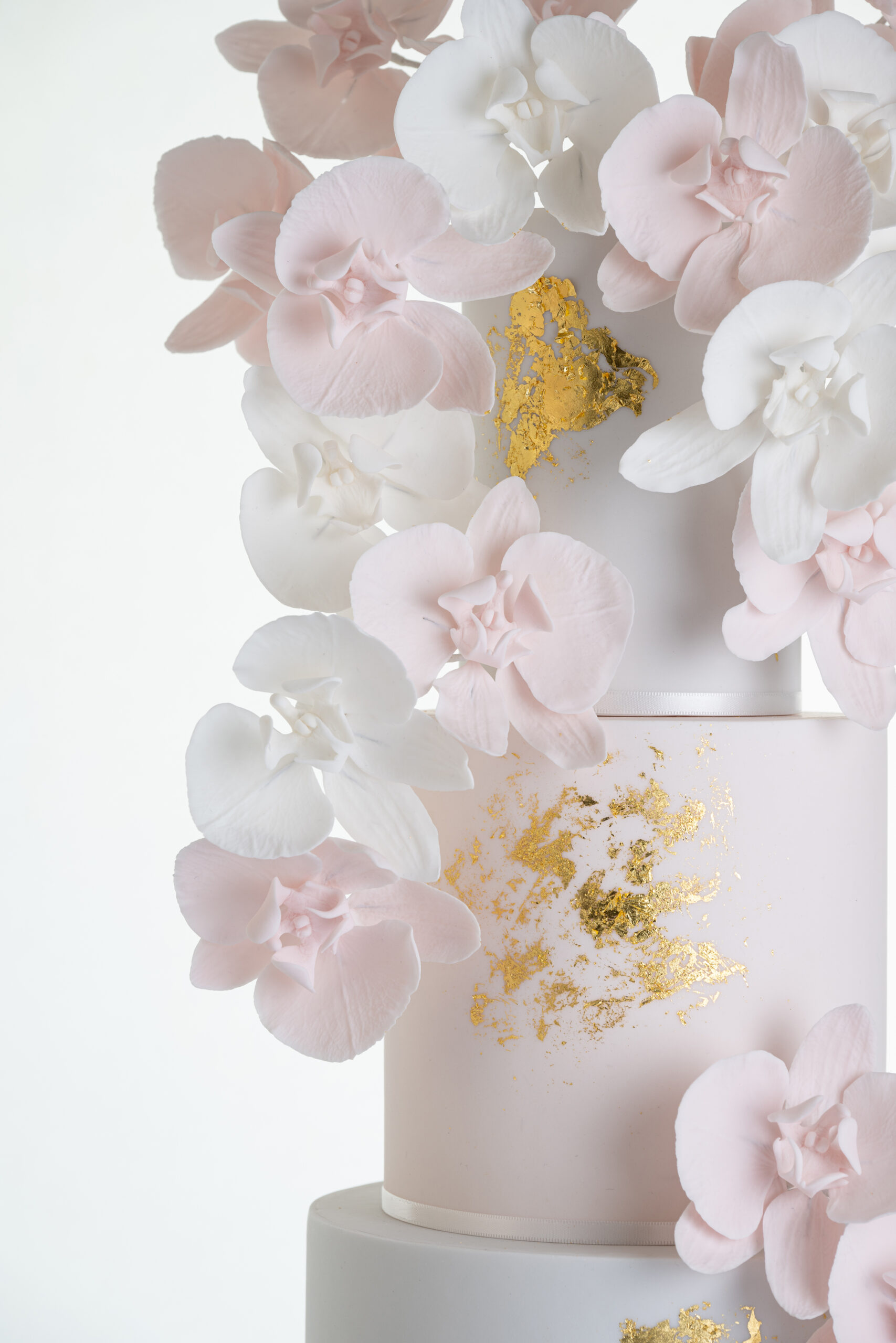 Top tier of luxury contemporary, customisable, wedding cake, Orchid Heaven by Decorum Taste, with brushes of edible gold leaf and bunches hand-crafted sugar orchids.