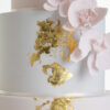 Detail of luxury contemporary, customisable, wedding cake, Orchid Heaven by Decorum Taste, with brushes of edible gold leaf and bunches hand-crafted sugar orchids.