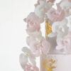 Detail of luxury contemporary, customisable, wedding cake, Orchid Heaven by Decorum Taste, with brushes of edible gold leaf and bunches hand-crafted sugar orchids.