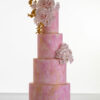 Four tier luxury customisable contemporary wedding cake, Painted Blush by Decorum Taste, in hand-painted pink tones with gold flecks, bouquet of hand-crafted sugar roses, hydrangea petals and trailing gold leaves.