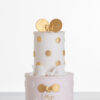 Two tier luxury contemporary, customisable, celebration cake, Polka Mouse by Decorum Taste, with decorative edible gold leaf circle embellishments, a pretty floral trim, cartoon mouse ears and sugar paste bow.