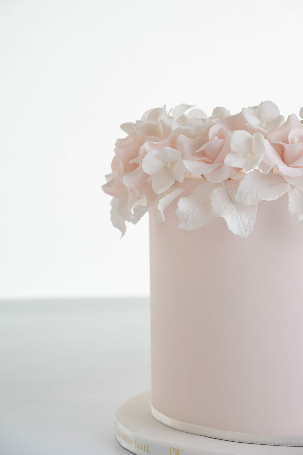 Detail of luxury contemporary, customisable, celebration cake, Ring of Roses by Decorum Taste, in blush pink with ring of hand-crafted sugar roses and petals at the top.