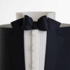 Detail of luxury contemporary, customisable, celebration cake, Tux Gent by Decorum Taste decorated in black the white of a formal shirt, tuxedo jacket and bow tie.