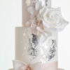 Top two tiers of luxury contemporary, customisable, wedding cake, Vintage Beauty by Decorum Taste with large hand-crafted sugar rose in ivory, brushed edible silver leaf and a silk bow.