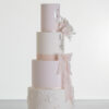 Four tier luxury contemporary, customisable, wedding cake, Vintage Beauty by Decorum Taste with large hand-crafted sugar rose in ivory, brushed edible silver leaf, decorative floral embellishments and a pink silk bow.