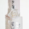 Top two tiers of luxury contemporary, customisable, wedding cake, Vintage Beauty by Decorum Taste with large hand-crafted sugar rose in ivory, brushed edible silver leaf and a silk bow.