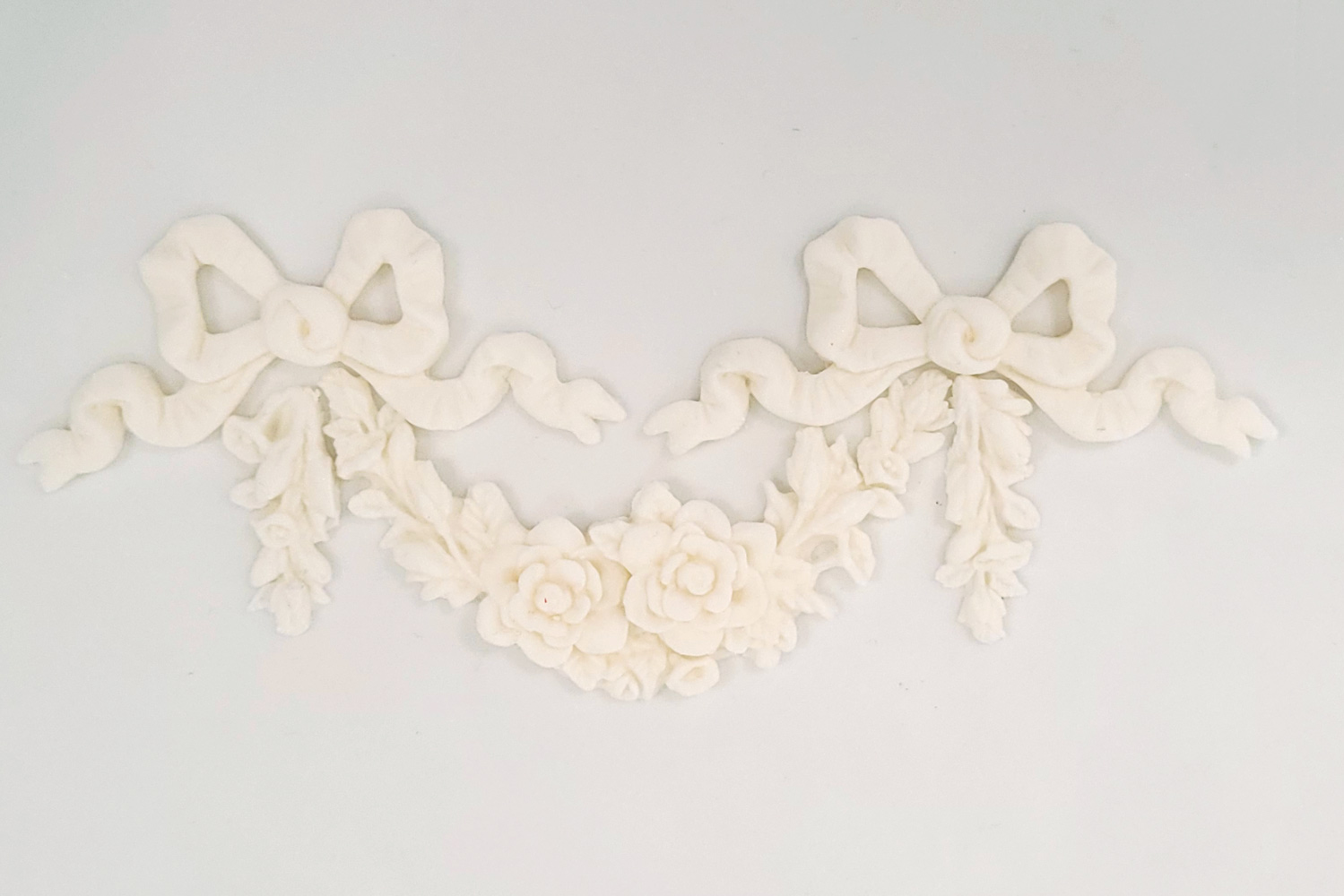 An intricate white sugarcraft bow decoration by Decorum Taste