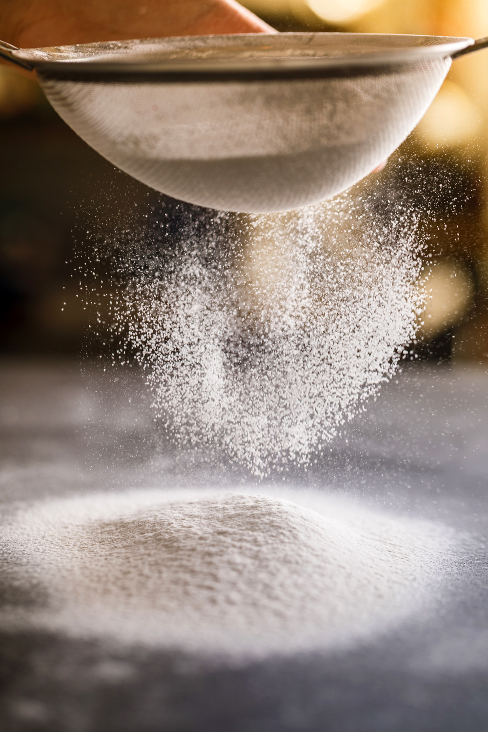 A look into the Decorum Taste cake creation process - this photo shows one of the team sifting flour.